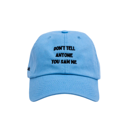 Light blue cap with subtle embroidered text “Don’t Tell Anyone You Saw Me,” sleek statement cap.