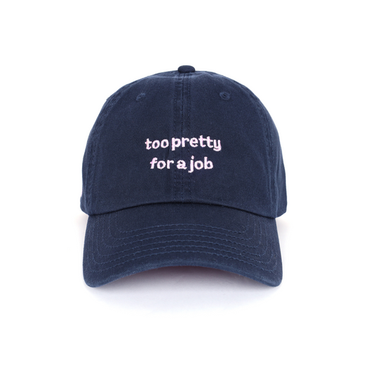Navy blue cap with 'too pretty for a job' text on a white background. trendy statement cap for women.