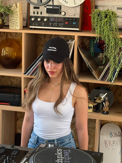 Person wearing a cap in a room with shelves containing records and plants